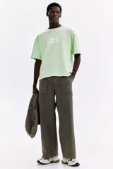 Pantalón jogger gris oscuro de punto grueso, con cintura elástica, cordón ajustable, bolsillos frontales de parche y piernas rectas.