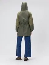 Campera tipo piloto con capucha, cierre frontal con botones y detalle de costuras en zigzag. Presenta cordones ajustables en la cintura y capucha, puños elásticos y logo bordado en el pecho.