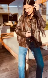 Campera de cuero color marrón claro, con flecos en la espalda y mangas.