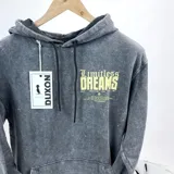 Canguro gris con efecto lavado y capucha, con estampa amarilla en la espalda con la frase "Limitless Dreams".