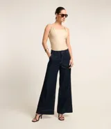 Pantalón de jeans azul oscuro, de corte ancho y cintura alta, con trabillas en la cintura y friso delantero.