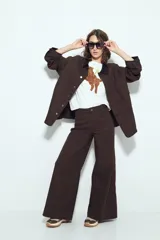 Pantalón de pierna amplia color marrón oscuro, confeccionado en denim con leve elasticidad, diseñado para un calce cómodo y relajado.