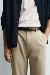 Pantalón de corte recto confeccionado en tejido elástico, con cintura elástica, pliegues frontales, bolsillos laterales y bolsillos traseros de vivo con botón.