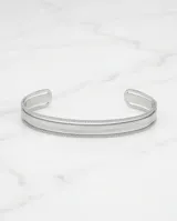 Pulsera tipo esclava rígida de acero, con diseño minimalista y bordes texturizados.
