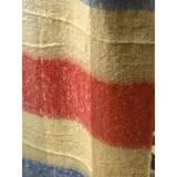 Bufanda rectangular de tejido grueso con diseño de cuadros en tonos azul, naranja, gris y beige, terminada con flecos en los extremos.