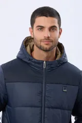 Campera puffer reversible para hombre, de color negro, con diseño capitonado, capucha integrada y bolsillos funcionales con cierre frontal.