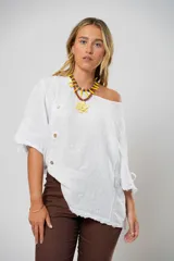 Blusa blanca de lino con corte asimétrico, mangas 3/4 con botones y cuello redondo amplio.