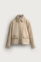 Cazadora relaxed fit de piel y ante color beige, con cuello solapa, manga larga con puño, bolsillos delanteros con solapa y cierre frontal oculto con cremallera y botones a presión.