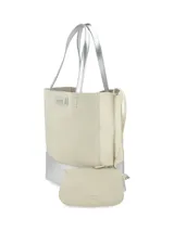 Cartera tipo tote de cuero color crudo con base y asas plateadas, de diseño vertical y rectangular con detalle de placa metálica con logo de la marca en el frente.