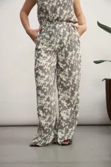 Pantalón de corte recto y tiro alto con estampado abstracto en tonos gris y crema. Presenta bolsillos laterales y cierre frontal.