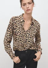Camisa fluida de corte recto con estampado animal print de leopardo, cuello camisero, manga larga y cierre frontal con botones.