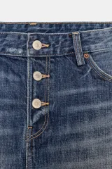 Falda corta de denim azul medio, tiro medio, con cierre frontal de botones y bajo deshilachado.