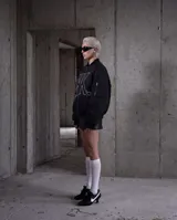 Campera bomber negra mate con diseño puffer, confeccionada en nylon impermeable. Presenta un gran logo bordado en color blanco en el frente, cierre frontal metálico, puños y bajo con elástico interno, y detalles de cierres en las mangas.