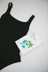 Malla entera negra con escote cuadrado y espalda cavada, confeccionada en lycra italiana con protección UV 50.