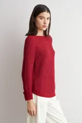 Sweater de punto con textura jaspeada en tonos marrones, de corte recto, cuello redondo y mangas largas. Presenta un diseño con ruedo curvo.