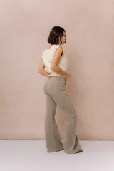 Pantalón de jean color arena con silueta wide leg, tiro medio-alto y costuras verticales delanteras que estilizan la figura. Cuenta con bolsillos funcionales y cierre frontal con doble botón.
