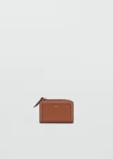 Billetera pequeña de cuero sintético con efecto saffiano color tostado, de diseño compacto con seis ranuras para tarjetas, bolsillo lateral con cierre de cremallera y cierre de solapa con botón a presión. Incluye detalle de costuras pespuntadas y el logo de la marca estampado en color dorado en el frente.