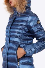 Campera azul metalizado con relleno de plumón sintético y capucha con borde de piel sintética.