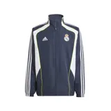 Campera deportiva Adidas del Real Madrid, color azul marino con detalles en blanco y amarillo. Presenta cierre frontal, cuello alto, bolsillos laterales, puños elásticos, dobladillo ajustable y escudo del club bordado en el pecho.