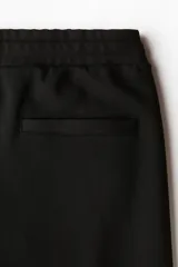 Pantalón tipo jogger de corte regular, confeccionado en tejido de punto de mezcla de algodón. Presenta cintura elástica con cordón de ajuste, pliegues frontales cosidos, bolsillos laterales y un bolsillo trasero insertado.