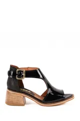 Sandalia de cuero charol negro con taco cuadrado símil madera, tira con hebilla metálica dorada en el tobillo y diseño de corte lateral.