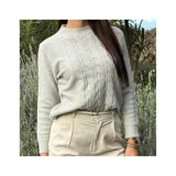 Buzo de punto blanco de manga larga con diseño trenzado y cuello redondo.