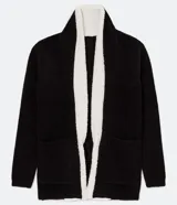 Cardigan largo de punto color negro, marca Blue Steel, con cuello de solapa y forro interior de peluche sintético blanco. Cuenta con mangas largas, bolsillos frontales aplicados y diseño abierto sin cierre.