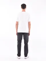 Remera de manga corta color gris topo, corte slim, con cuello redondo y un estampado gráfico en el pecho que combina texto manuscrito con un diseño abstracto en tonos oscuros.