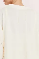 Remerón manga corta color crudo, con detalle de recorte en la espalda. Realizado en jersey de algodón y poliéster.