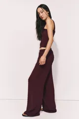 Pantalón ancho de tiro alto color bordó, con textura plumeti (pequeños puntos en relieve) y cintura elástica fruncida con cordón ajustable.