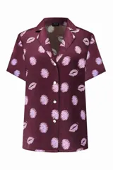 Camisa de manga corta color burdeos con estampado de labios color lila, confeccionada en crepé de seda con botones dorados y crudos.