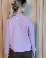 Camisa de manga larga con estampado de rayas verticales en tonos crudo y beige. Presenta cuello alto con volados, cierre frontal con botones dobles y puños con volados.