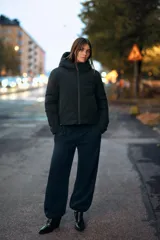 Anorak de corte corto y diseño minimalista, color negro. Cuenta con capucha integrada, cierre frontal con cremallera termosellada, bolsillos laterales con cierre y puños interiores elásticos. Posee acolchado interior y propiedades resistentes al agua y al viento.
