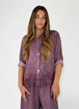Camisa de manga larga color violeta, con cierre frontal de botones y detalle de encaje aplicado en el ruedo.