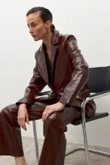 Blazer de eco cuero color chocolate con textura de cocodrilo, cuello alto y solapas.