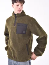 Buzo negro de polar con cuello alto y medio cierre. Tiene un bolsillo plaqué en el pecho con cierre y tirador.