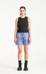 Short de baño de calce regular, color lavanda, con cintura elástica ajustable mediante cordón negro. Posee bolsillos laterales y un pequeño parche negro con un logo de tijeras cruzadas en la parte inferior frontal.