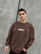 Buzo marrón de algodón con cuello redondo, puños y cintura acanalados. Estampa frontal con el logo de la marca en color blanco.