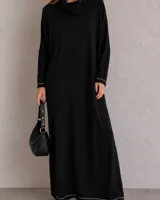 Vestido largo negro con cuello envolvente y mangas largas.
