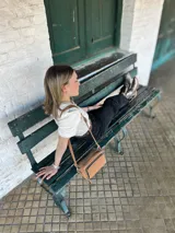 Bandolera color camel de cuero con forro de tela, bolsillo interior y exterior.