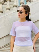 Remera de tul color lila con lunares blancos, mangas cortas y cuello redondo.
