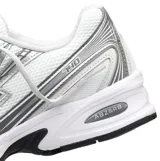 Championes New Balance modelo 740, con diseño retro inspirado en el running de los años 2000. Presentan una capellada de malla transpirable en color blanco con superposiciones sintéticas en gris y detalles en azul claro. Incluyen entresuela con tecnología ABZORB para absorción de impactos y suela de goma resistente.