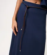 Pollera midi de corte recto, confeccionada en mezcla de viscosa y lino, en color azul marino. Cuenta con cintura con pasacintos, calce estructurado y un cinturón fino de material sintético con lazo delantero.