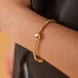 Pulsera extensible de malla en oro 18k, con diseño bicolor en oro amarillo y blanco, y detalle de esfera central pulida.