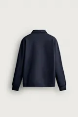 Sudadera polo de corte regular, confeccionada en tejido técnico interlock de algodón con elasticidad. Presenta cuello solapa, cierre frontal de cremallera y manga larga con puños acabados en rib.