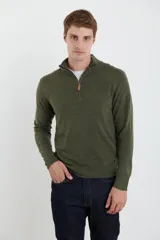 Sweater verde oliva de tejido acrílico con textura similar al cashmere, corte clásico, cuello alto con cierre metálico y tirador de cuerina ecológica.
