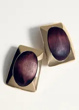 Aros de diseño rectangular en tono dorado con incrustación ovalada central de madera en color marrón oscuro.