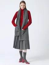 Bufanda larga de tejido gris melange, con bolsillos en los extremos.