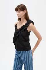 Musculosa de algodón color negro con escote en V profundo, tirantes finos y un volado diagonal fruncido que cruza desde el hombro izquierdo hasta el dobladillo.