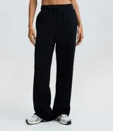 Pantalón de corte recto confeccionado en algodón con felpa, de color marrón. Presenta cintura elástica con cordón ajustable y diseño holgado.